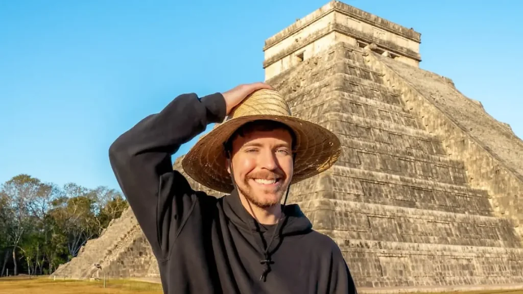 MrBeast sonriendo y ajustando un sombrero de paja frente a la pirámide de Kukulkán en Chichén Itzá.
Youtuber MrBeast visitando las ruinas mayas de Chichén Itzá en México.
MrBeast con un sombrero de sol frente a la pirámide principal de Chichén Itzá.
Imagen de MrBeast explorando la antigua ciudad maya de Chichén Itzá.
MrBeast en México posando frente a la pirámide de Kukulkán bajo un cielo azul.