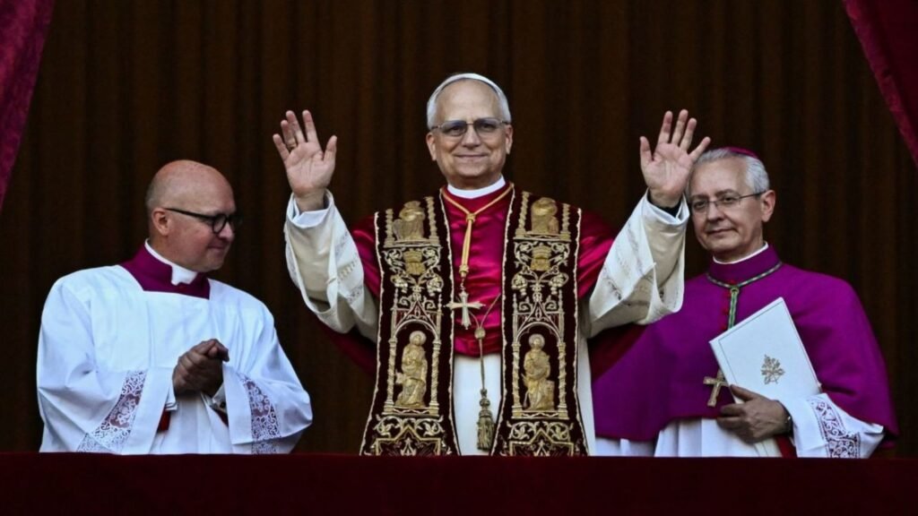 El Papa Francisco bendiciendo entre el Cardenal Prevost y otro clérigo con vestimentas religiosas desde un balcón.
El Santo Padre con estola bordada bendiciendo junto a dos obispos (uno con muceta morada) en un evento público.
Fotografía del Papa Francisco con el Cardenal Robert Francis Prevost y otro líder religioso en un balcón.
Bendición papal: el Papa Francisco con las manos levantadas junto a dos figuras eclesiásticas.
Imagen del Papa Francisco flanqueado por dos clérigos (Cardenal Prevost a la izquierda) dando una bendición desde un balcón.